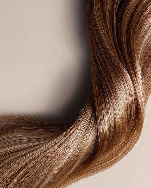 Close-up of wavy blonde hair on a neutral background
